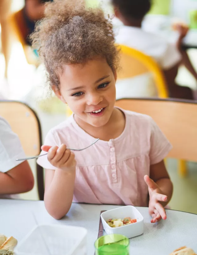 serunion-educa-niña-afro-riendo-comiendo